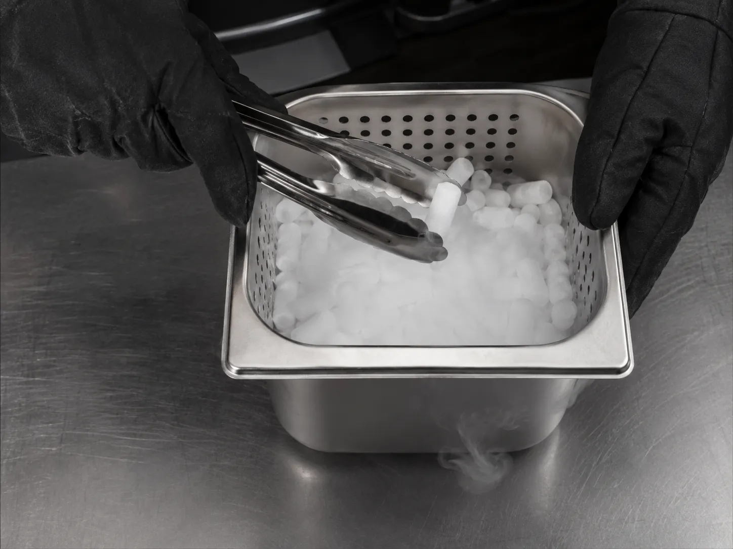 Manipulación de hielo seco con pinzas y guantes térmicos